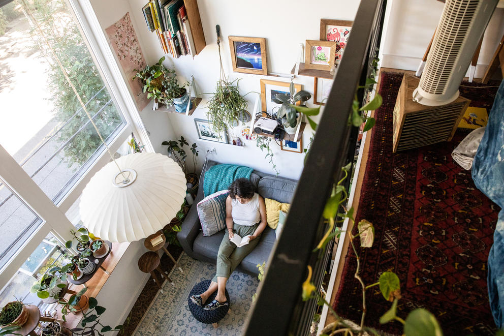 Overhead view of a woman sitting in her furnished apartment