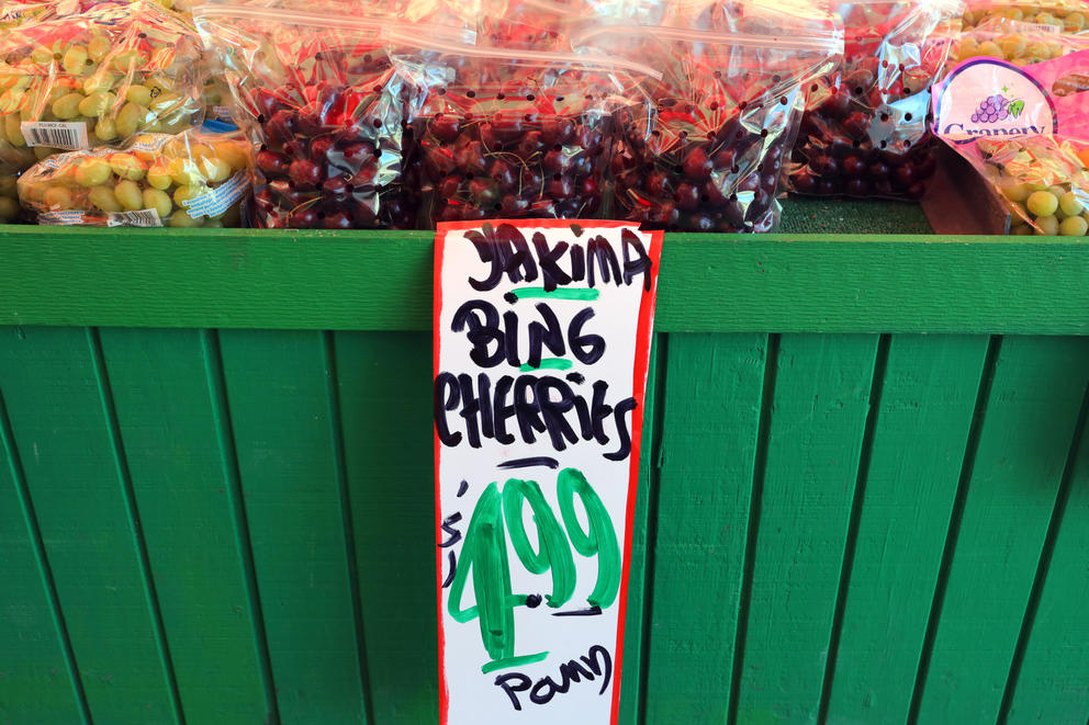 Display of cherries with a sign describing them in front 