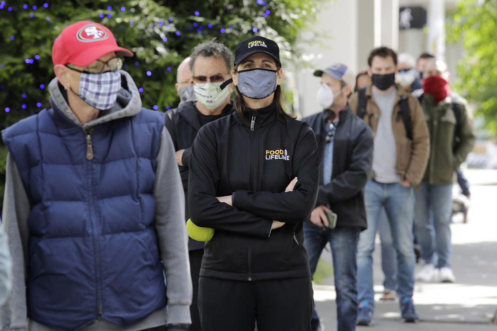 People in masks stand in line