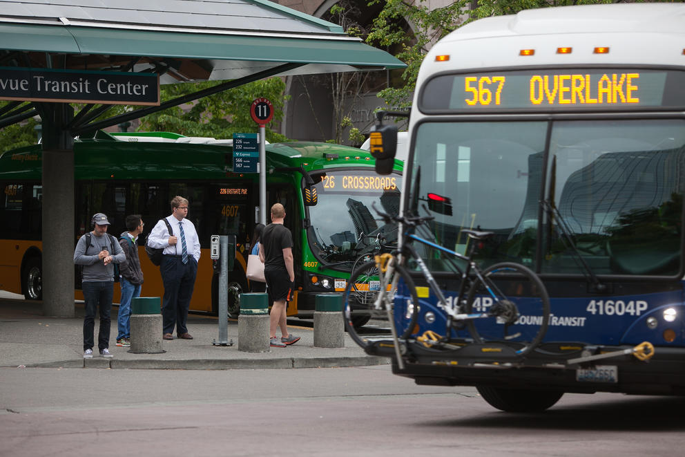 A King County Metro bus stops as a Sound Transit rolls out