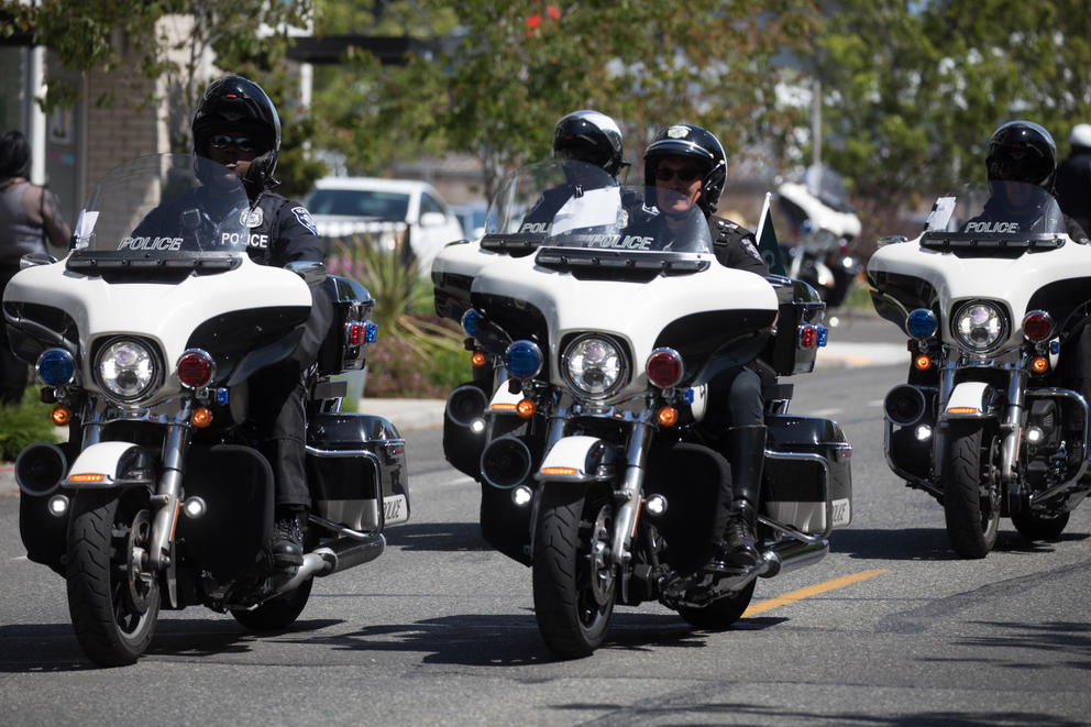 Seattle police officers riding down a street on motorcycles