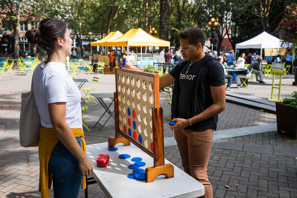 Two people playing Connect Four in Occidental Park