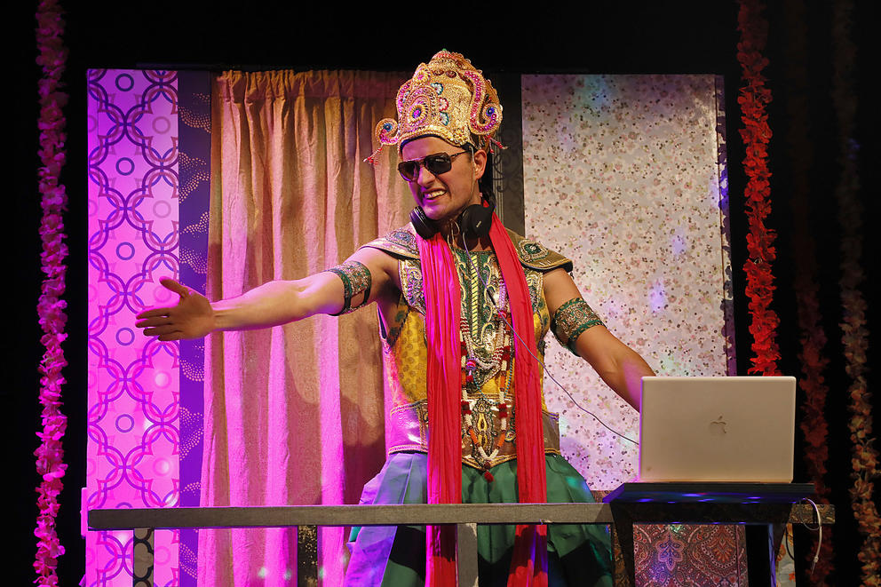 An actor in Indian-style garb performs on stage