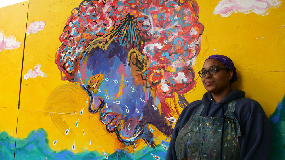woman standing next to mural