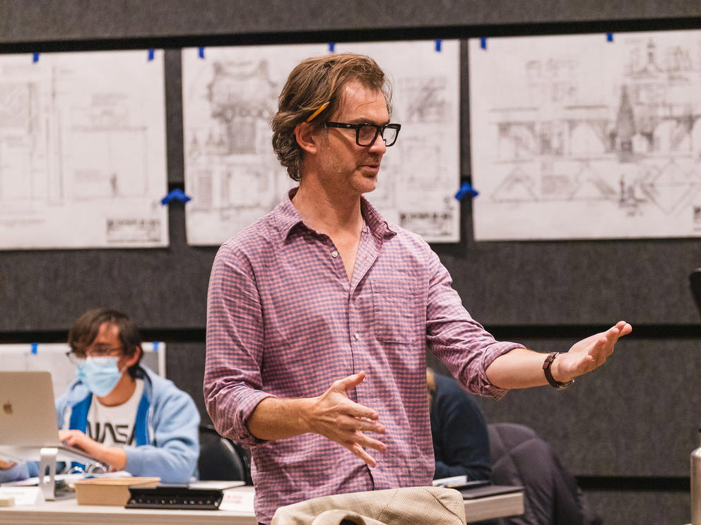 photo of a man in glasses directing a play rehearsal 