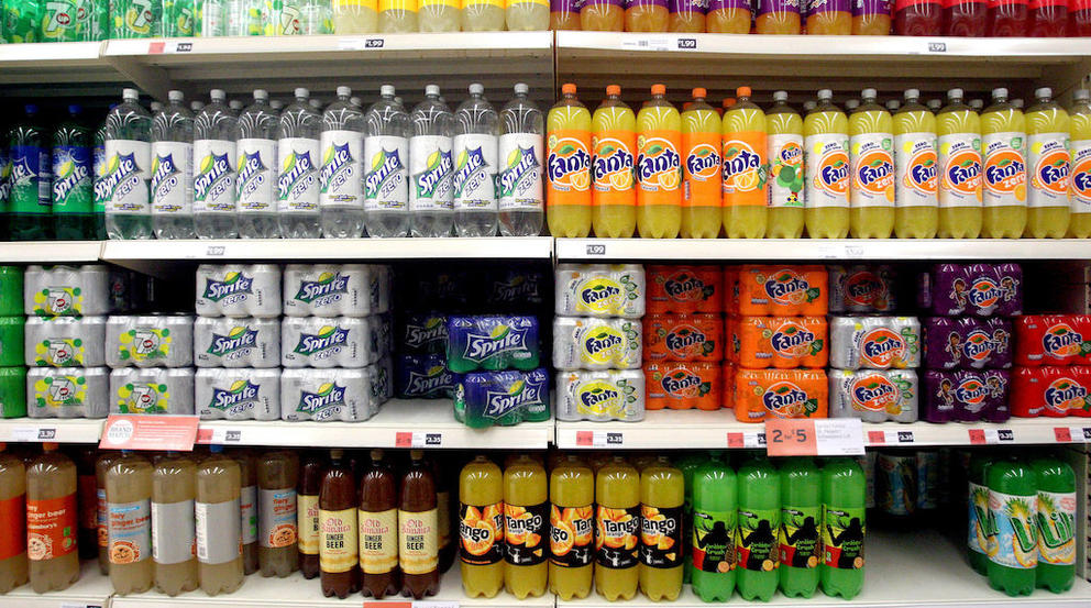Cans of soda stacked inside a supermarket.