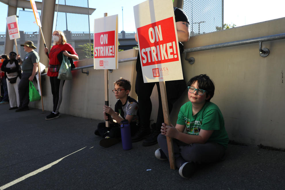 Students hold signs that say 'on strike!'