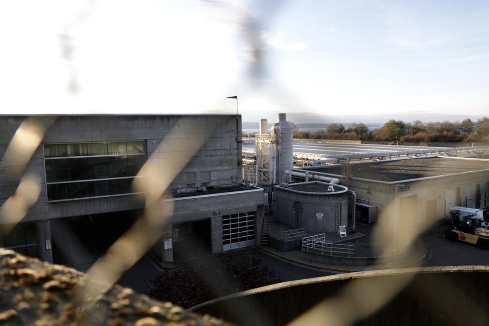 King County's West Point Treatment Plant in Seattle's Discovery Park, as seen through a chain link fence. 