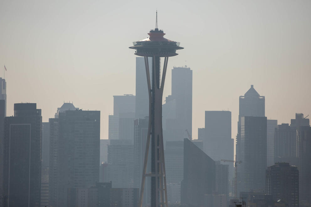The space needle in front of a smoky downtown Seattle skyline