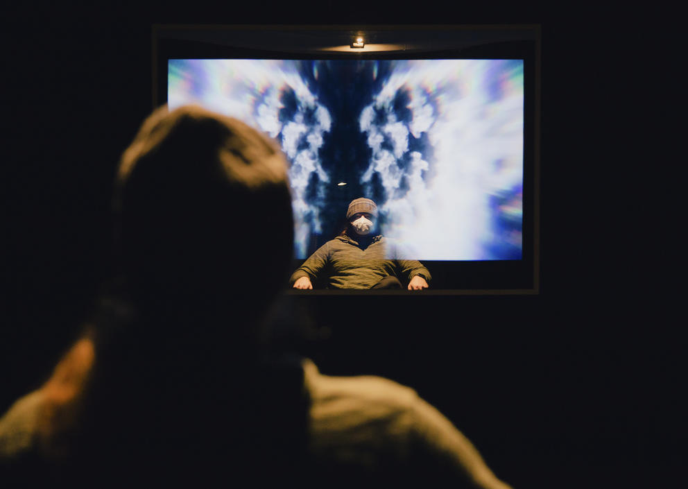 Person in front of a screen in dark room