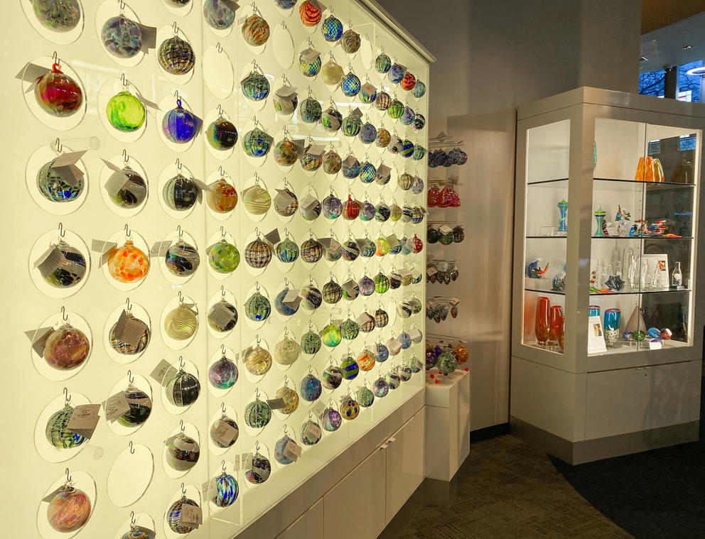 photo of a lit wall showcasing many rows of spherical glass ornaments 