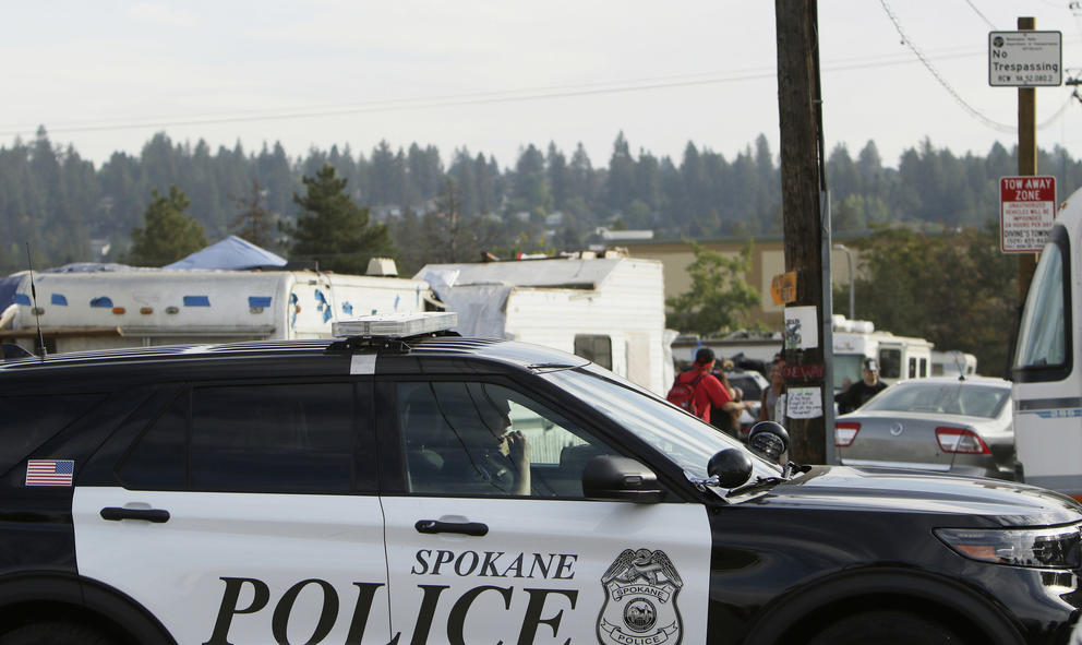 A police vehicle drives by the Camp Hope encampment 
