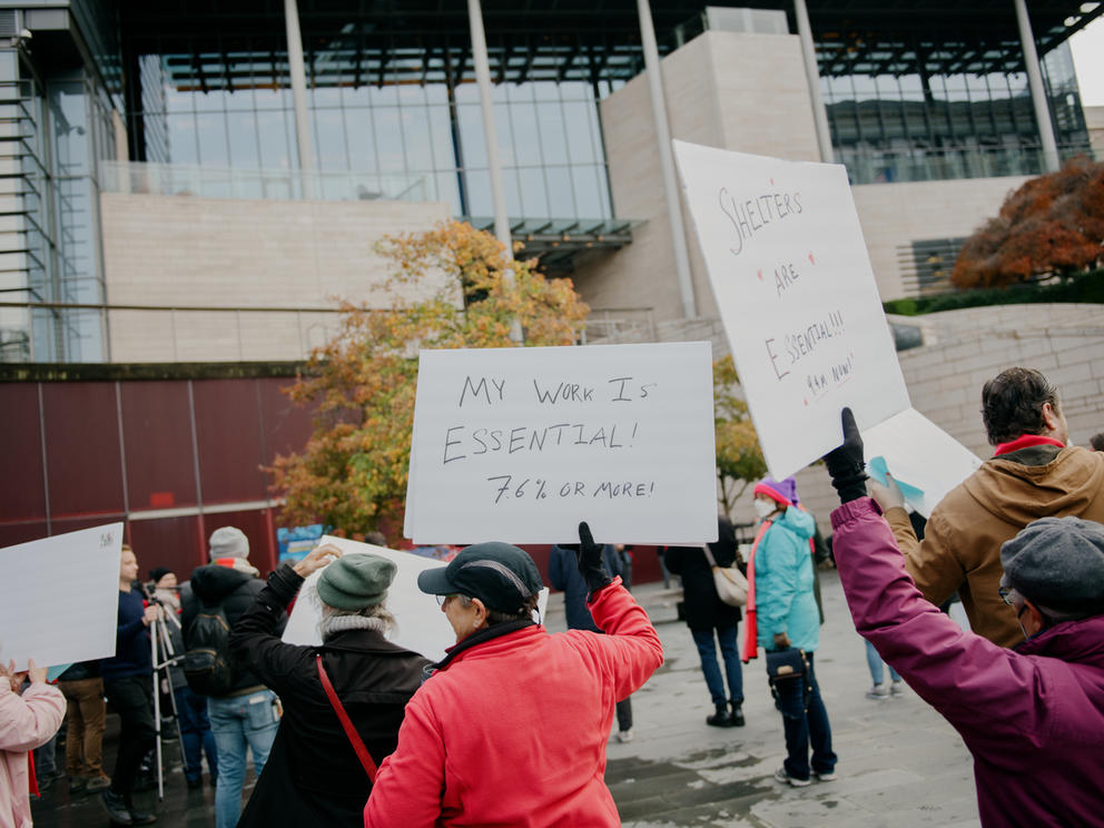 human service workers hold signs at a rally outside of seattle city hall 