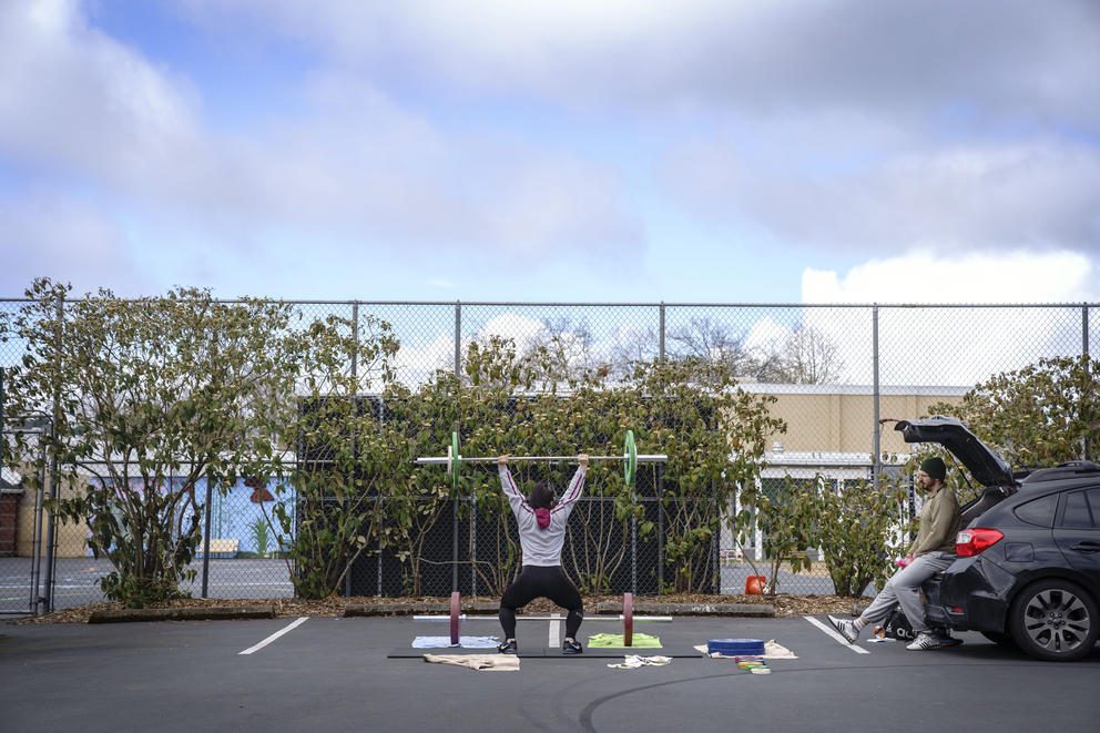 Two people work out in a parking lot