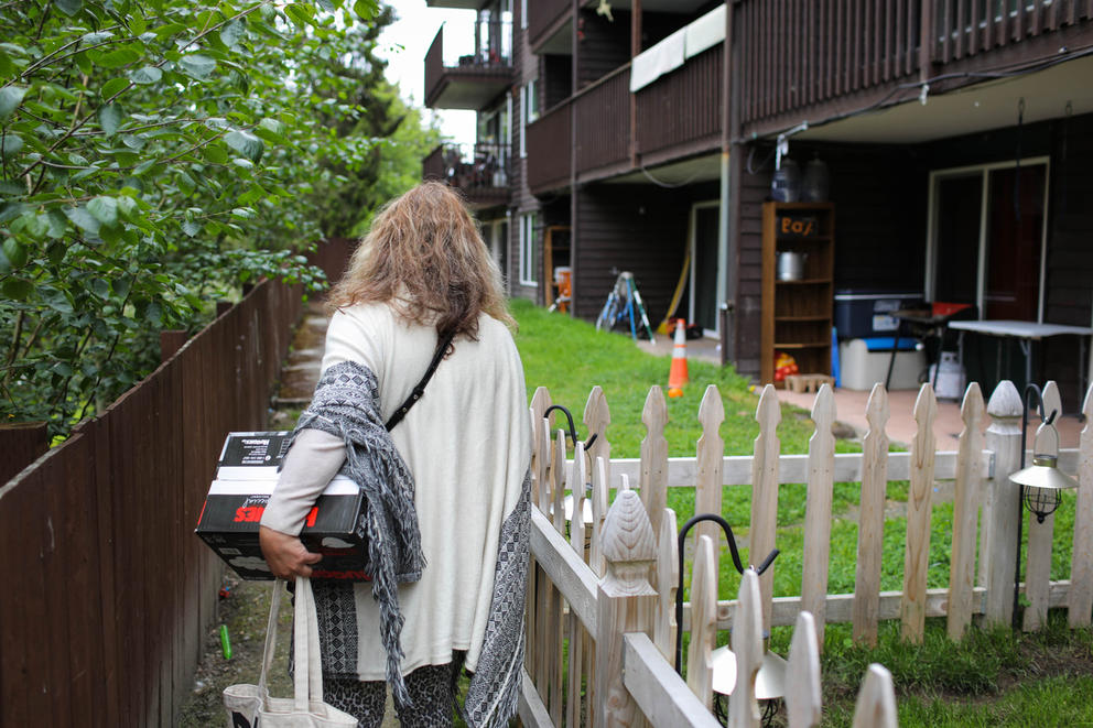Margarita Celis carries a box of diapers as she makes a house call to one of her clients.