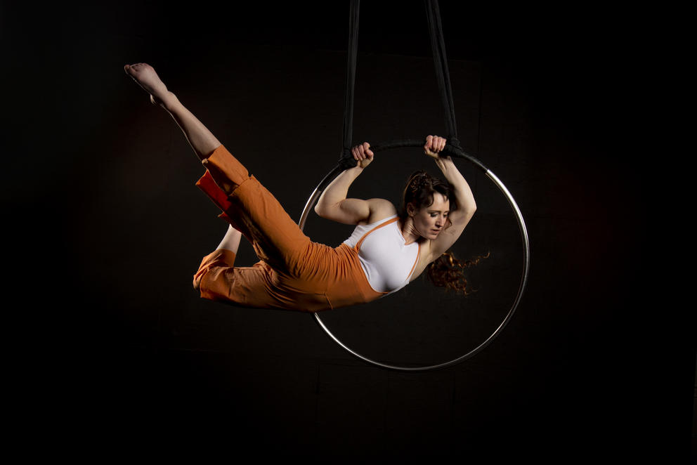 Acrobat in a ring in the air, on a black background