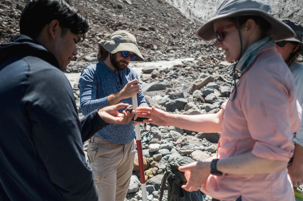 Three students measuring rocks