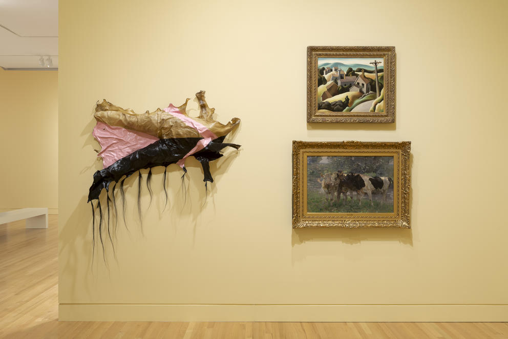 photo of a gallery installation with a wall sculpture and two paintings