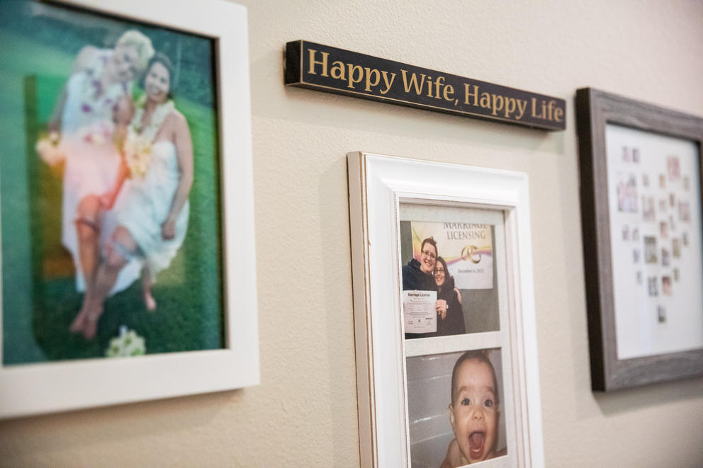 Framed family photos and a sign reading "happy wife, happy life" on a wall