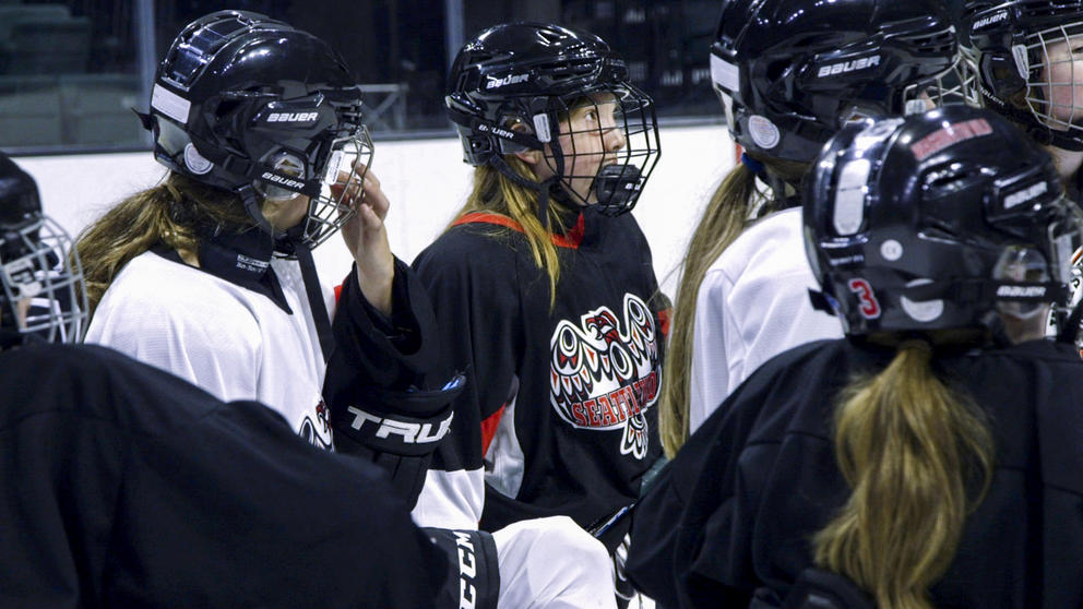 11-year-old Mackenzie Demoors listens as her hockey coach gives instructions for the next exercise during practice at a rink in Everett, Washington.