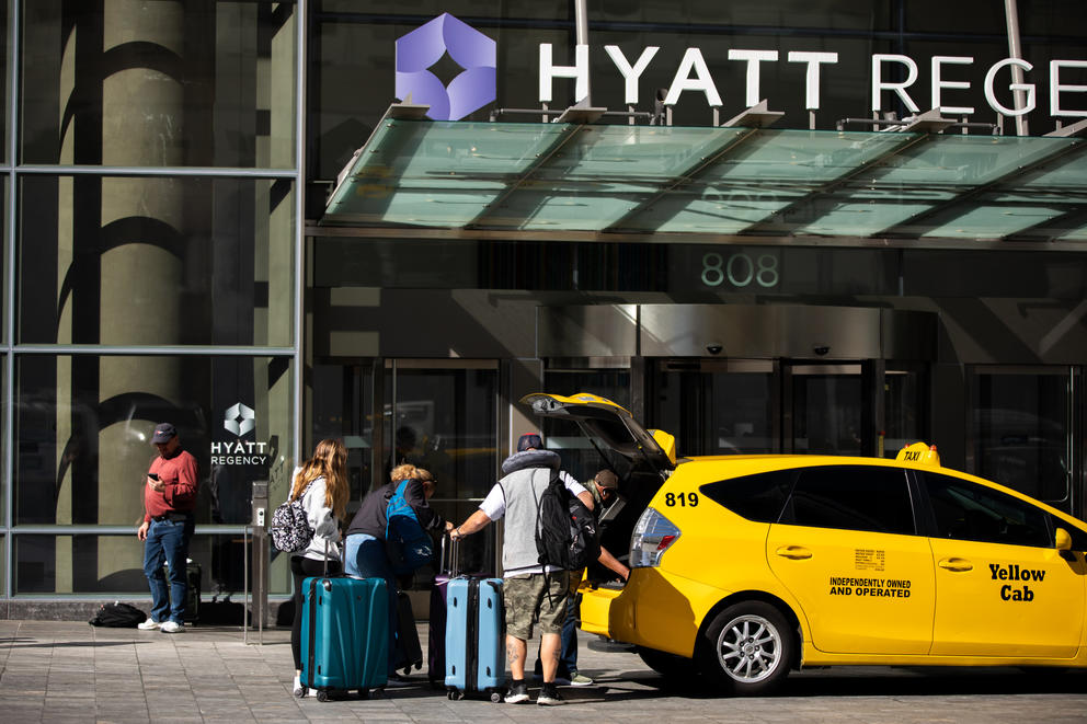 Hotel guests unload their bags from a taxi outside the Hyatt Regency Seattle