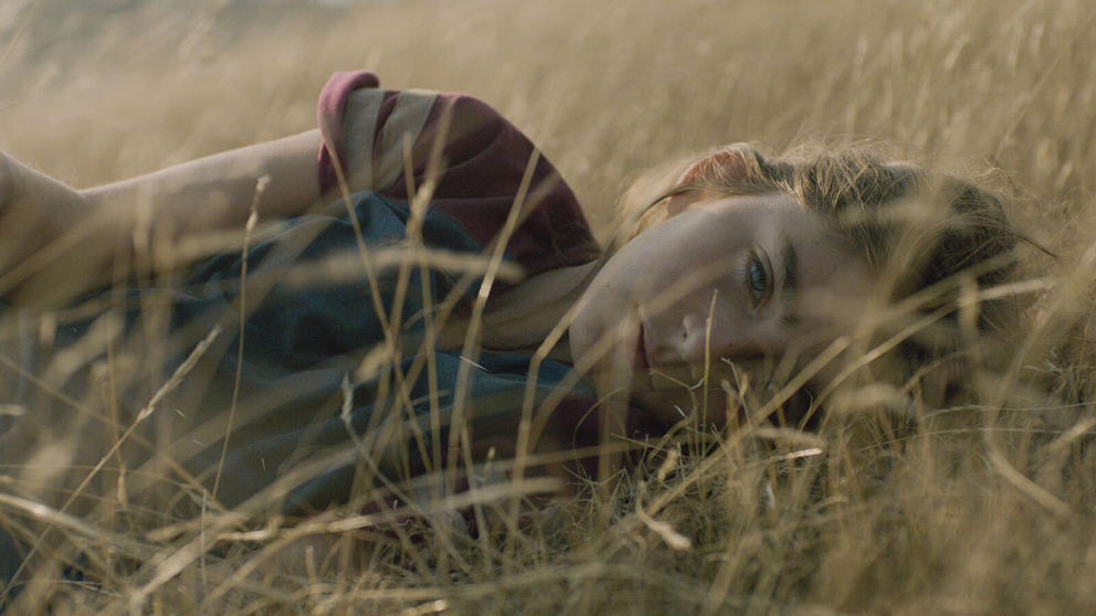 a girl lies in the grass