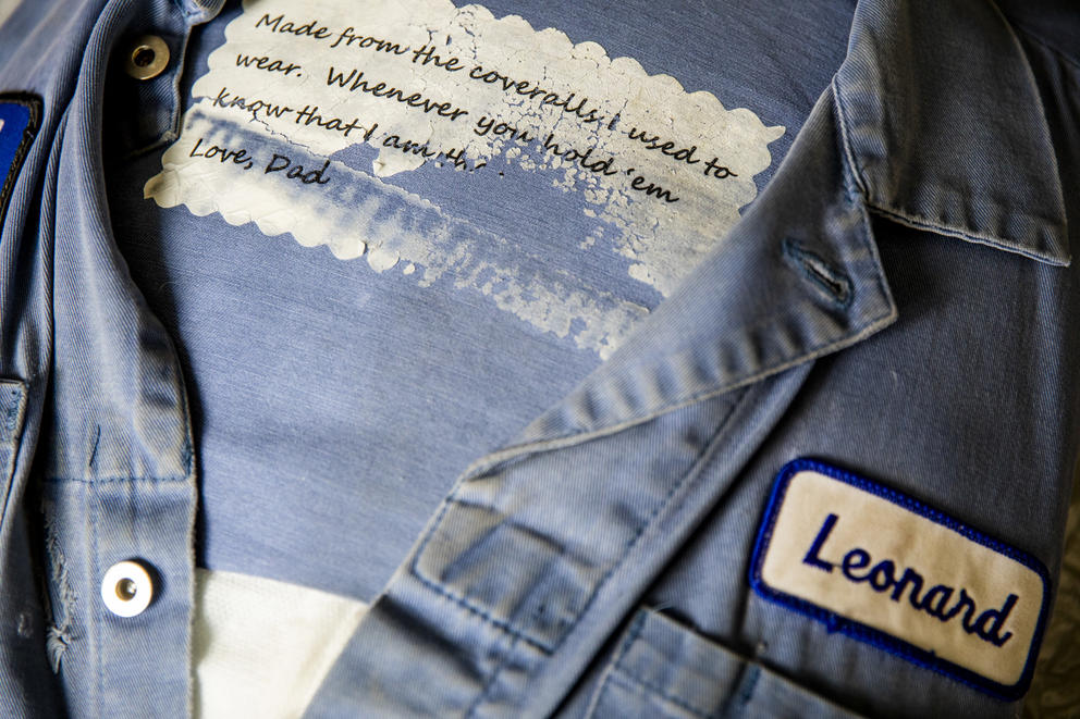 A pillow made of pair of coveralls with Leonard Thomas' nametag and a message to his son, Elijah