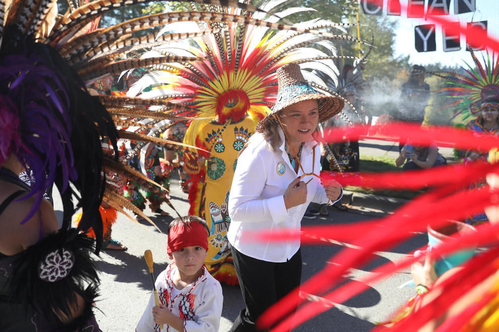 Fawn Sharp walks among marchers dressed in Indigenous regalia