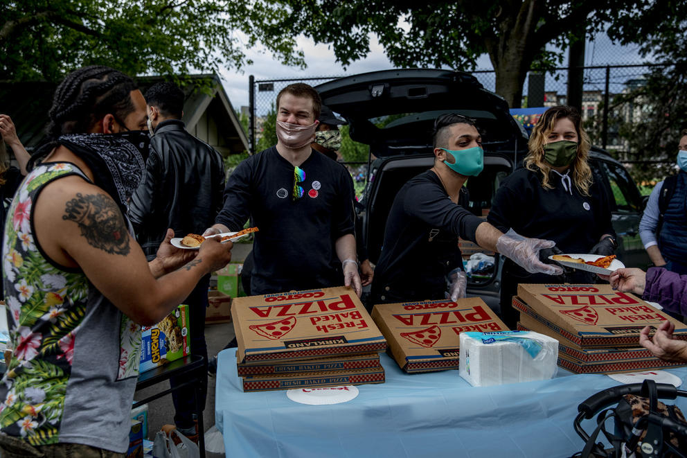 people handing out pizza