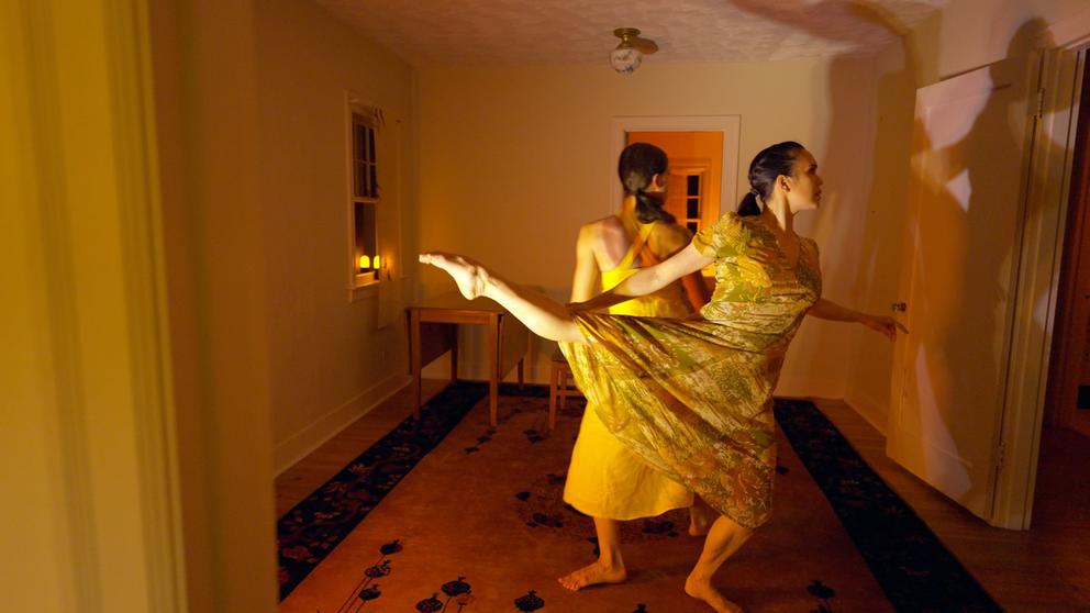 two dancers in a room bathing in yellow light