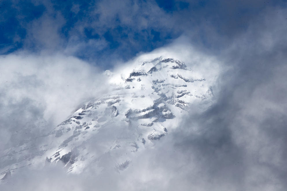 a snow-covered mountain peak amid clouds