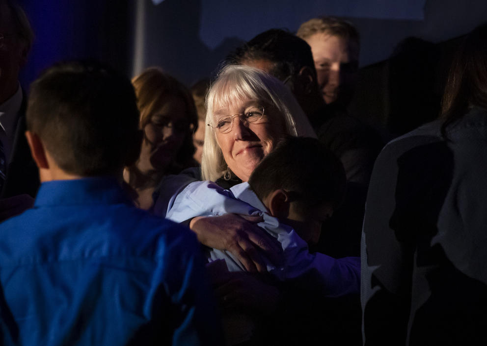 A close up of Patty Murray hugging a family member in a crowd
