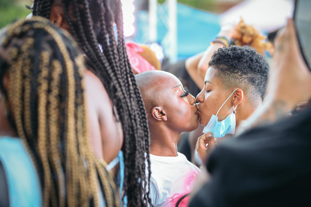 Two people kiss in a crowd