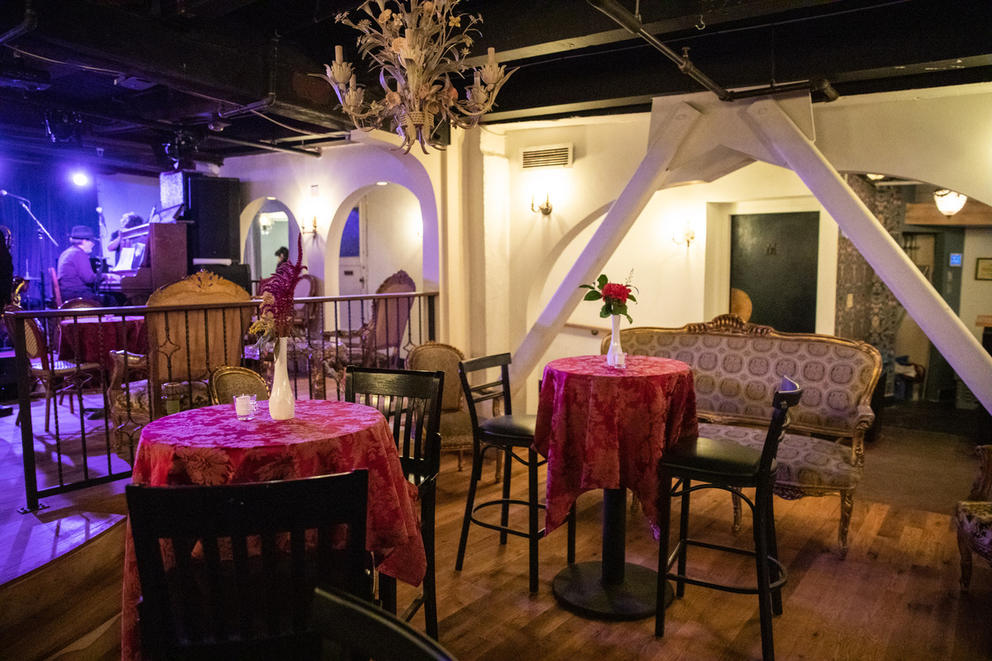 tables with table cloths in an underground venue with a stage