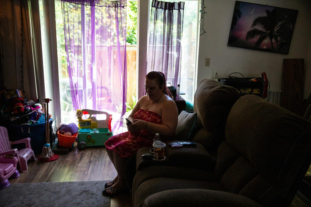 a woman sitting down talking on the phone in her apartment in Kent, Washington