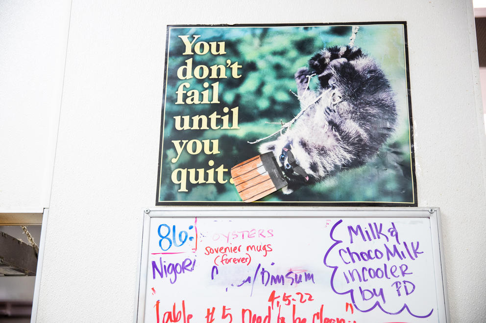 A poster hangs on a wall reading "You don't fail until you quit."