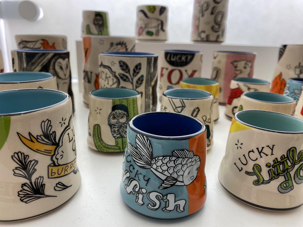 a photo of many small ceramic cups decorated with pictures of animals