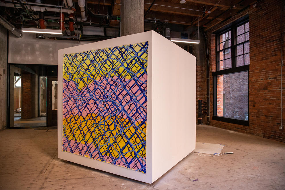 A big, colorful cube stands in an abandoned space