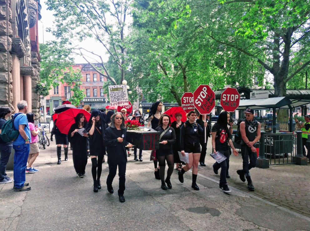 Sex workers carrying casket marked R.I.P Sex Workers in a street