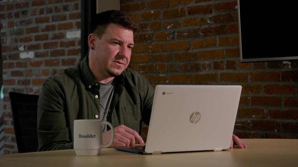A man sits at a laptop computer.