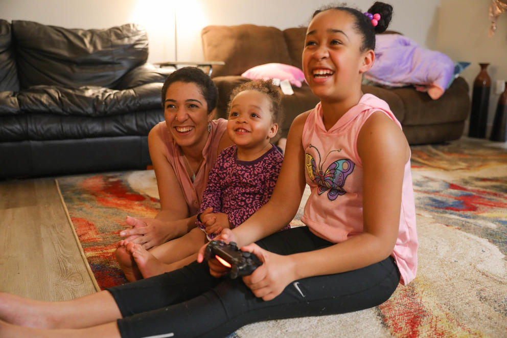 Sequoia Dolan and her daughters Zayah, 2, and Jaeleah, 10, play video games at home before dinner.