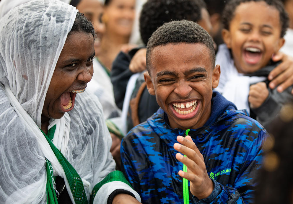 Young people smile as they are sprayed with holy water
