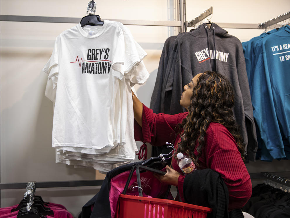 A woman browses through Grey's Anatomy novelty tshirts