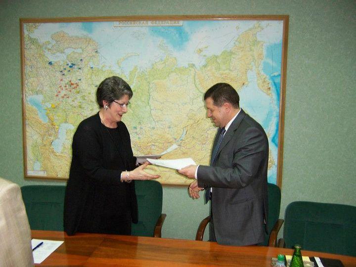 Woman signing agreement with man