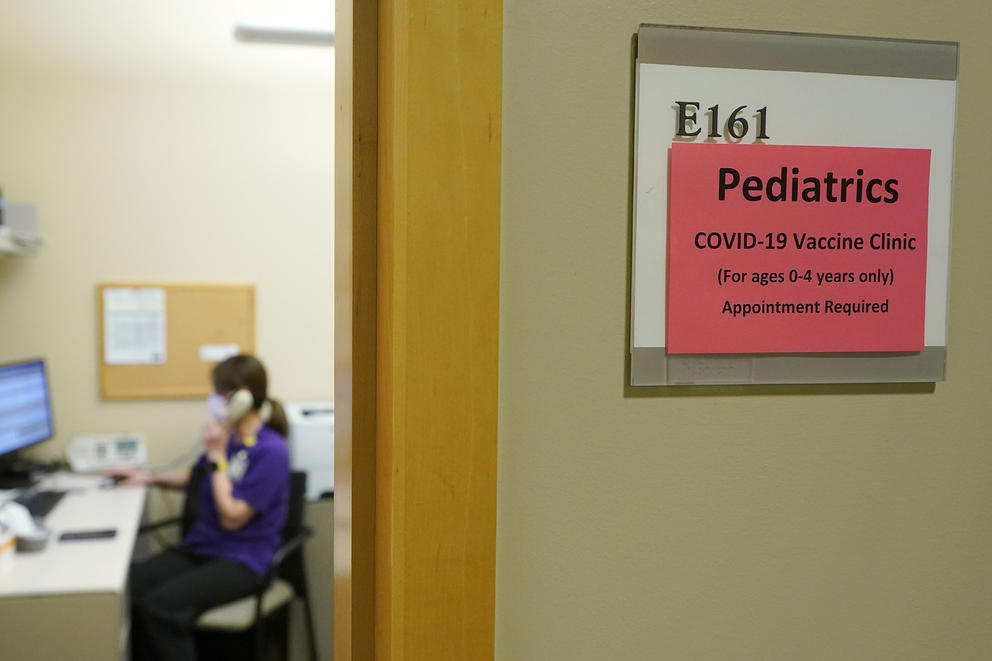 Sign outside a medical exam room reads "Pediatrics - COVID-19 Vaccine Clinic (For ages 0-4 only) - Appointment required"