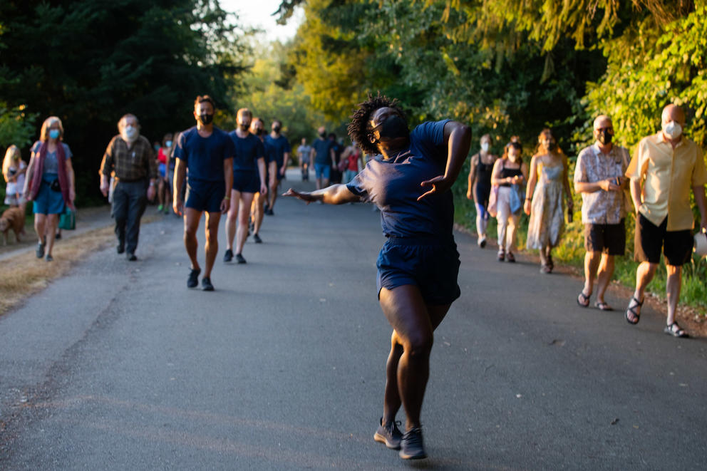 dancers perform outdoors on a paved pathway