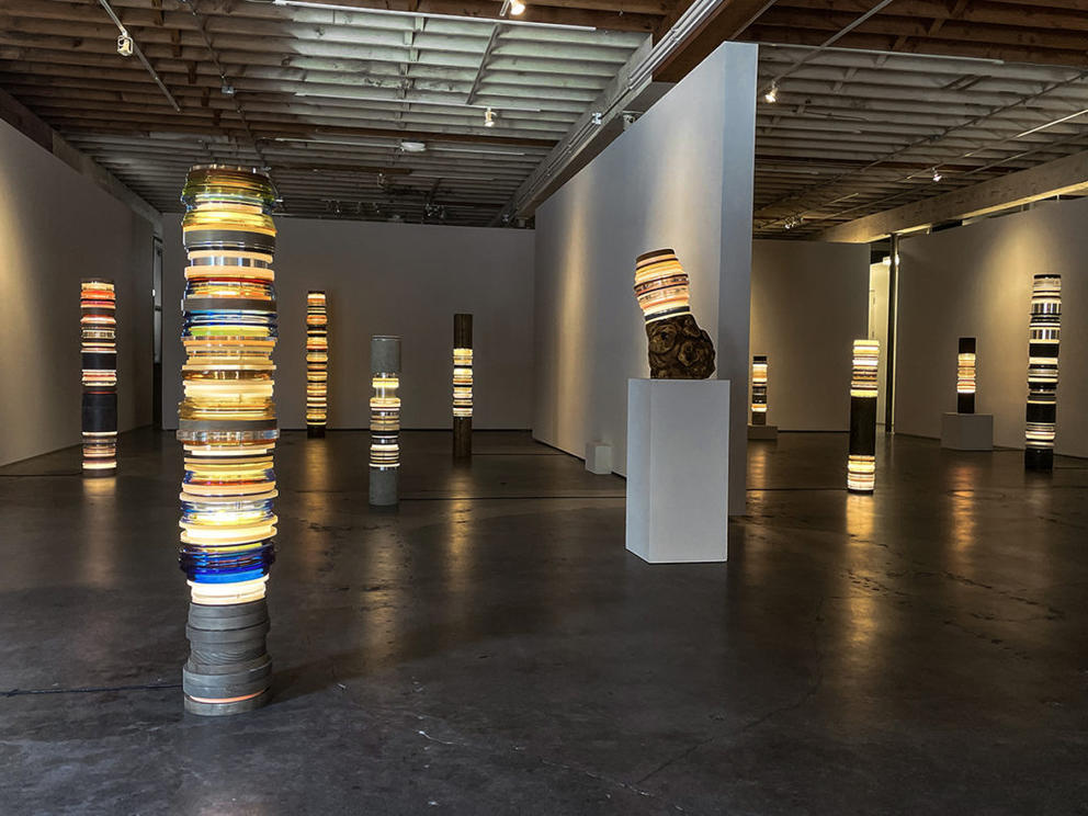 a gallery show of tall stacked sculptures