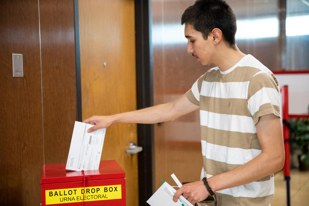 Man dropping a ballot into a ballot box