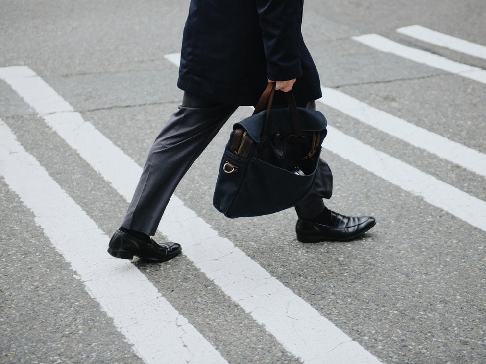 a close up of a man's legs crossing the street in the crosswalk