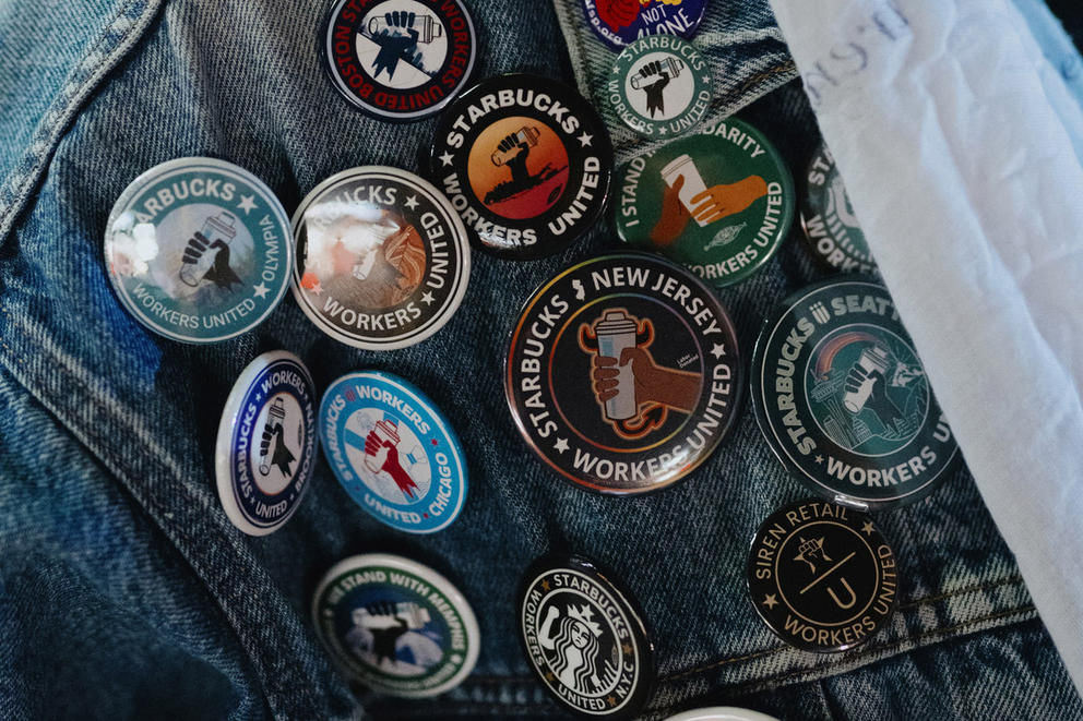 A number of Starbuck union pins on a denim jacket